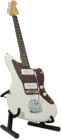 The image shows a white/cream Fender Jazzmaster-style electric guitar with a dark tortoiseshell pickguard, two single-coil pickups, a rosewood fretboard with white dot inlays, and chrome hardware. It features a traditional Fender headstock and a signature on the lower body. The guitar rests on a black adjustable A-frame stand, highlighting its classic offset design and well-maintained condition.