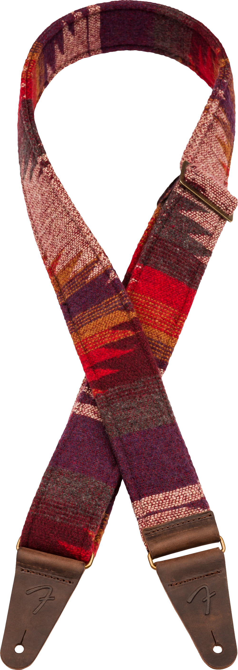 The image shows a guitar strap with a southwestern-inspired woven textile pattern in warm reds, burgundy, orange, and cream tones. It has brown leather end tabs with metal grommets for attachment and embossed branding. This decorative strap combines functionality—allowing the guitar to be worn standing—with a vintage, bohemian aesthetic that complements the player’s style.