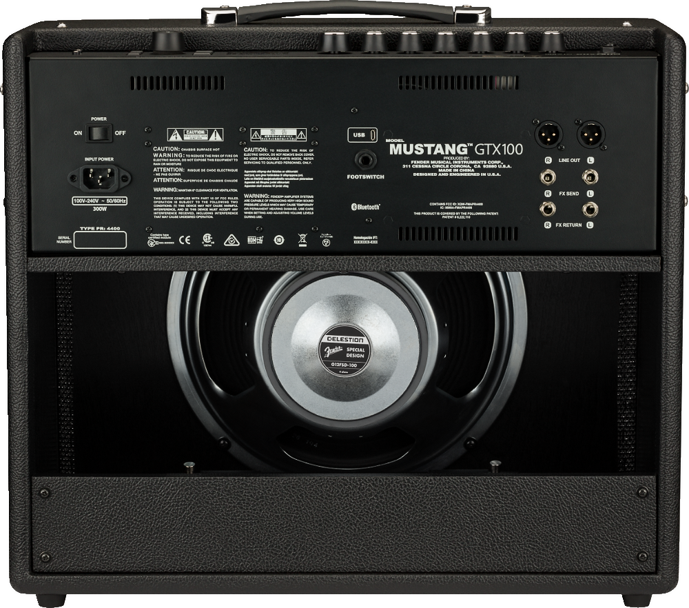 The image shows the rear view of a Fender Mustang GTX100 guitar amplifier. It features an open-back design with a visible 12-inch Celestion speaker, labeled "MUSTANG GTX100." Connectivity includes XLR outputs, line out, FX send/return, footswitch jack, USB, Bluetooth, AC power input, and an on/off switch. The amp has black tolex, metal corner protectors, and a handle. It is a 100-watt digital modeling amp from Fender’s Mustang series.