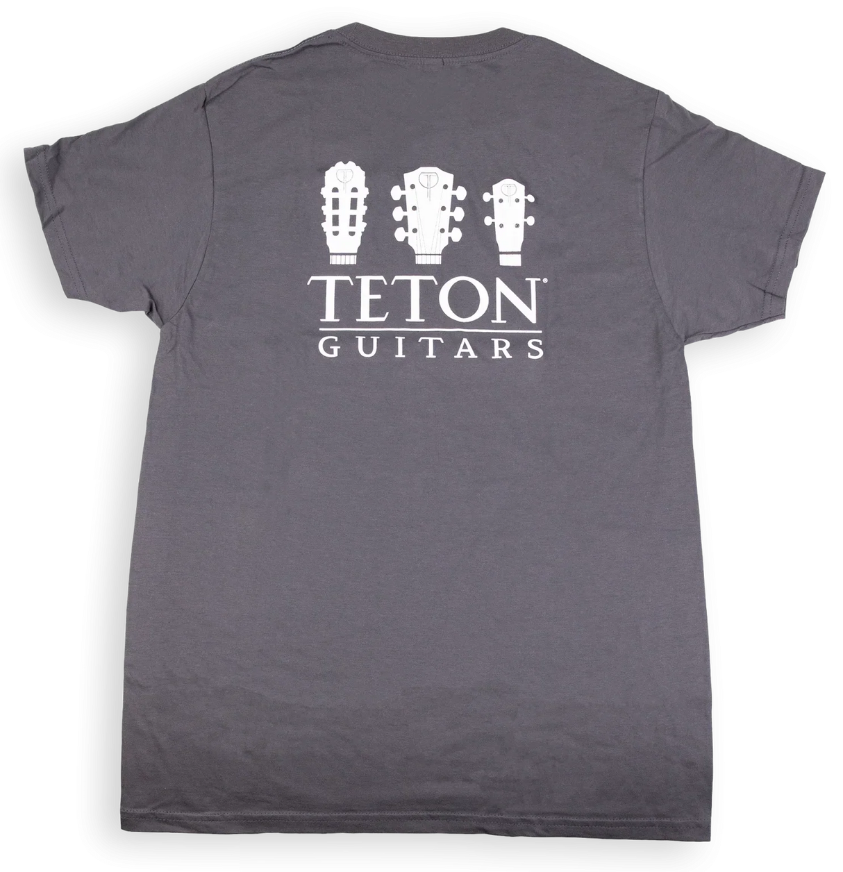 The image shows a dark gray t-shirt with "TETON GUITARS" branding. It features three white guitar headstock silhouettes—a classical guitar, an acoustic steel-string guitar, and a smaller instrument like a ukulele or mandolin—above the text. This minimalist design promotes Teton Guitars, a guitar manufacturer, and serves as branded merchandise for musicians and guitar enthusiasts.