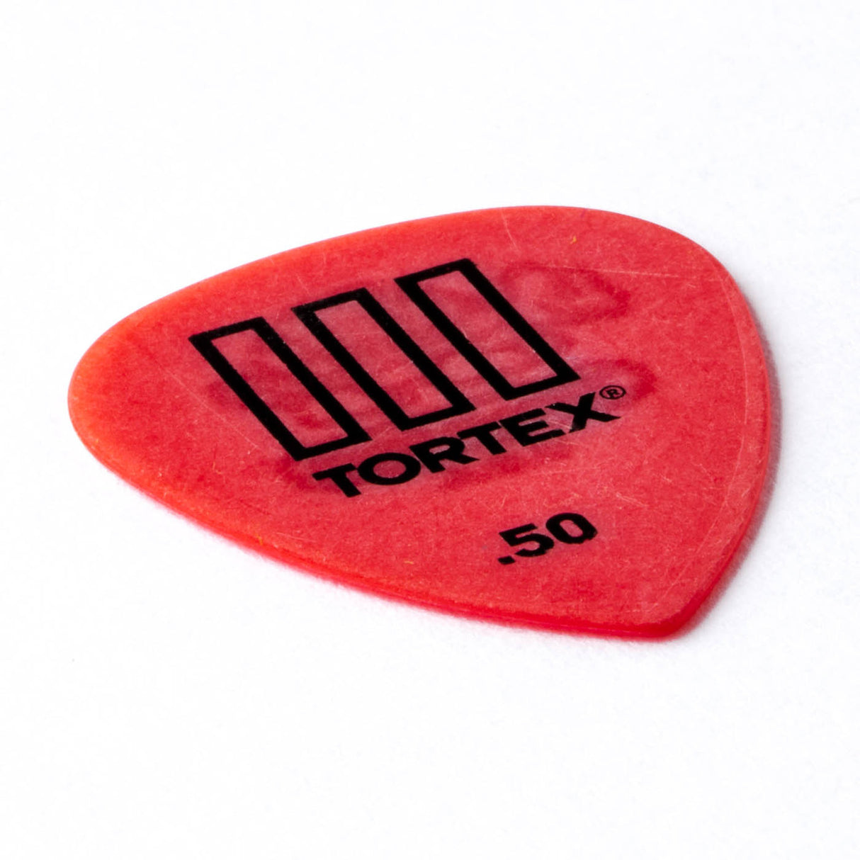 Red guitar pick with 'Tortex' branding on a white background