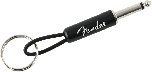 The image shows a Fender-branded keychain designed to look like a guitar cable. It features a 1/4" guitar plug on one end, a metal keyring on the other, and a black cable-like connector with the white Fender logo. This music-themed accessory mimics an instrument cable and is a novelty item for guitar players and Fender fans to carry keys while showing brand loyalty.