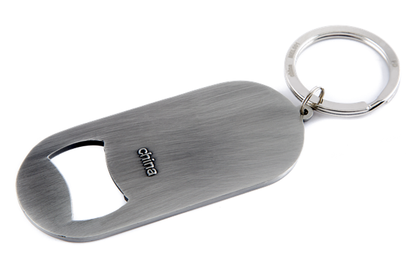 The image shows a sleek, brushed metal Gliga-branded bottle opener keychain with an oval shape and attached keyring. Gliga is a renowned maker of string instruments like violins and cellos. This practical promotional item combines utility with brand visibility, likely given as a gift or sold alongside their instruments to engage musicians and music enthusiasts.