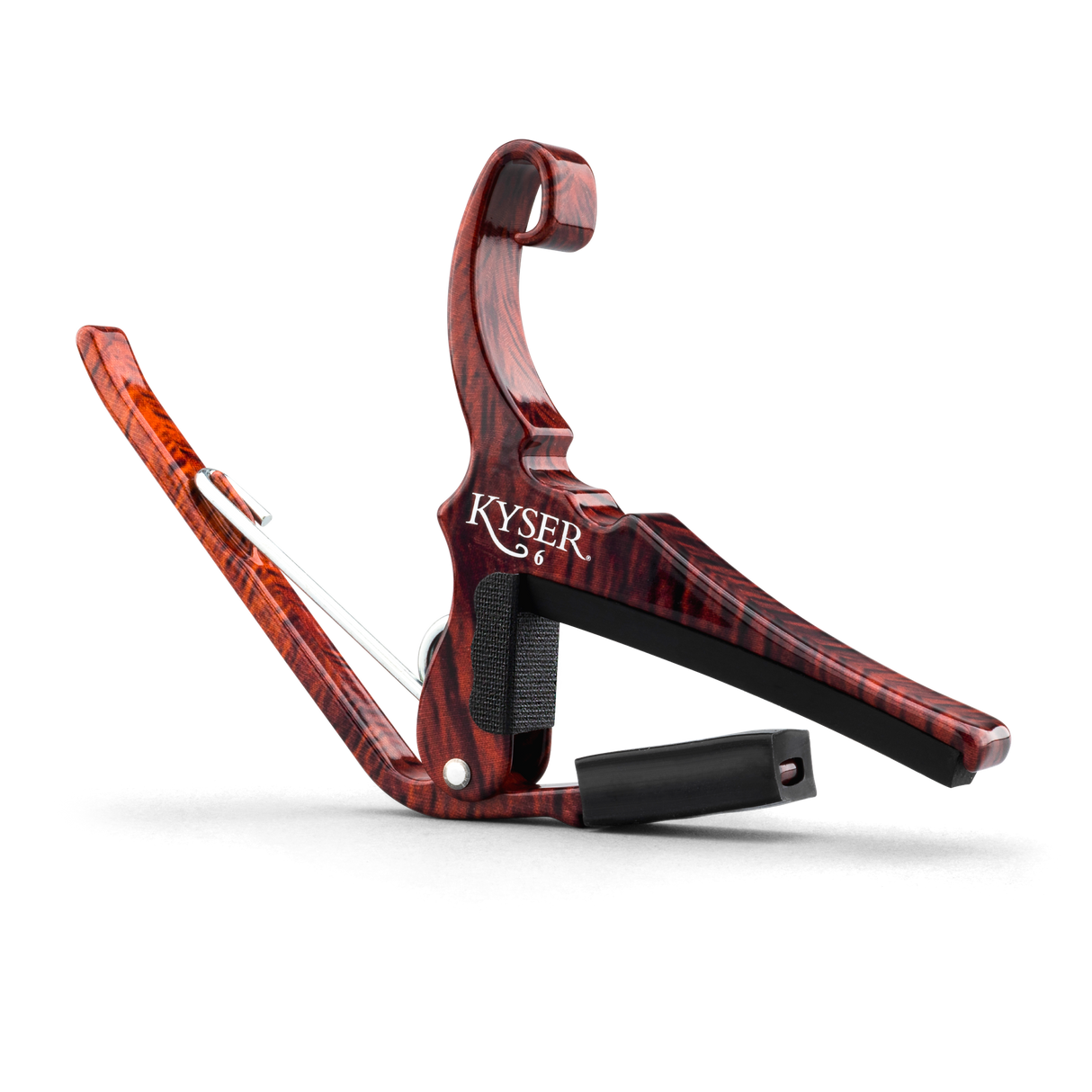 The image shows a Kyser guitar capo with a reddish-brown wood grain finish resembling rosewood. It features a spring-loaded clamp and curved handle for one-handed use, a black rubber pad that presses the strings, and a black fabric strap for secure attachment. This quick-change style capo raises the pitch by clamping the fretboard, allowing guitarists to easily change keys while using familiar chord shapes.