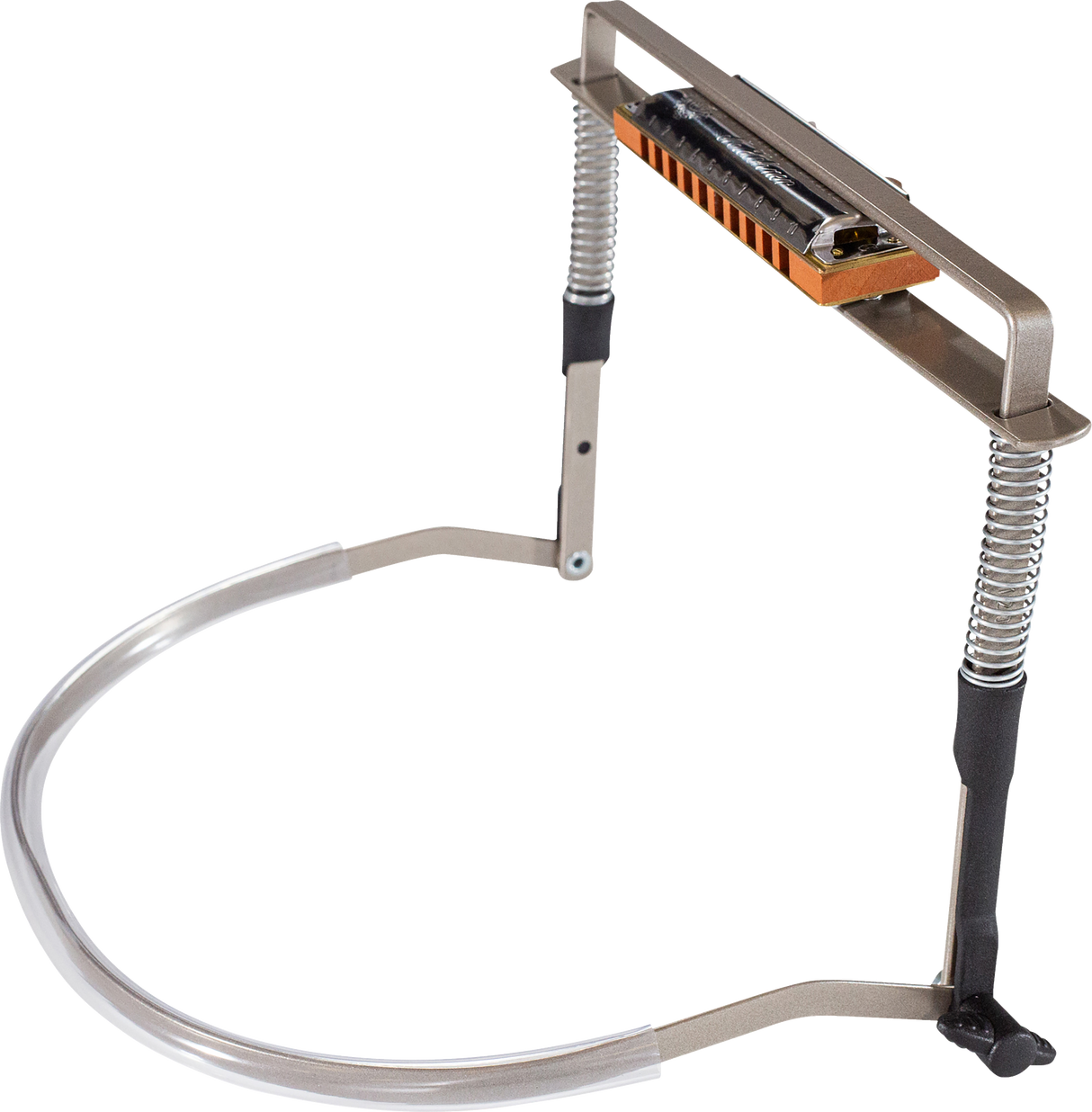 The image shows a harmonica holder, a hands-free metal frame with an orange/wood-colored harmonica mounted on it. It features a curved neck strap with flexible coiled sections and adjustable parts to position the harmonica for playing. This accessory is popular among folk and blues musicians, allowing them to play harmonica while playing other instruments like guitar.