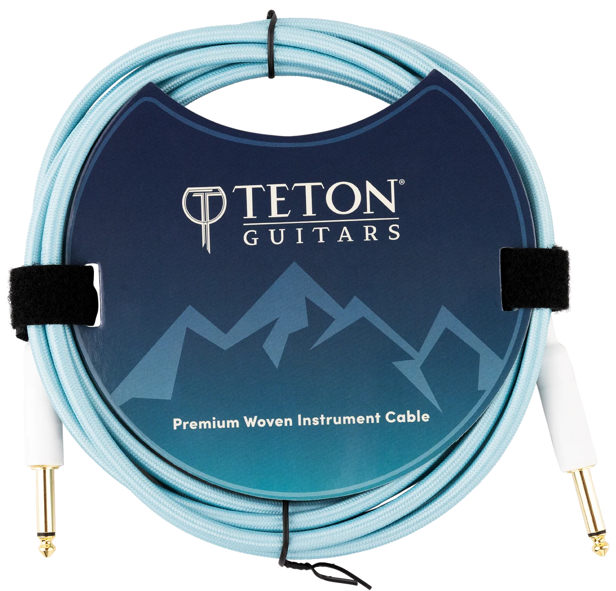 The image shows a Teton Guitars Premium Woven Instrument Cable with a light blue/turquoise woven fabric exterior for durability and style. It has gold-plated 1/4" connectors on both ends for optimal signal transfer. The packaging features the Teton Guitars logo and mountain design. The cable is coiled and secured with velcro straps, highlighting its quality build ideal for electric guitars and basses.
