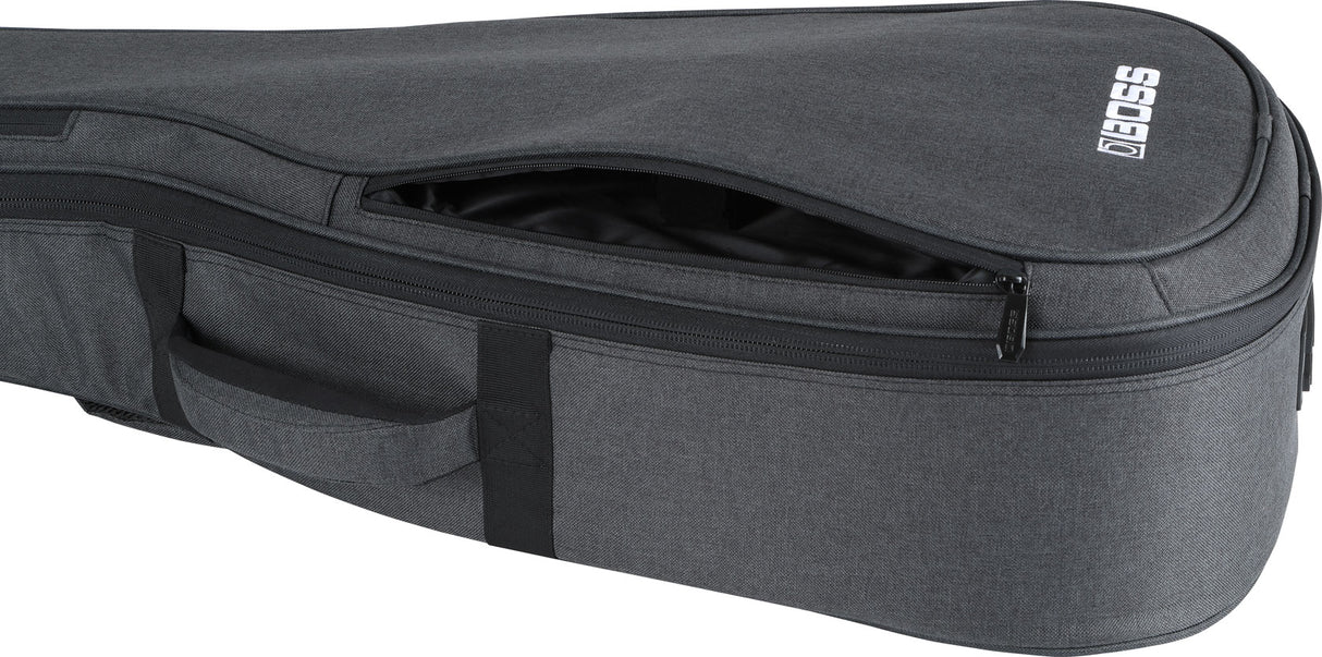 The image shows a grey/charcoal padded BOSS guitar gig bag with a partially open zippered main compartment revealing a black interior. It has a front zippered pocket for accessories, side carrying handles, and durable nylon-like fabric. This lightweight, protective soft case is popular for transporting acoustic or electric guitars and is branded by the well-known musical equipment maker BOSS.