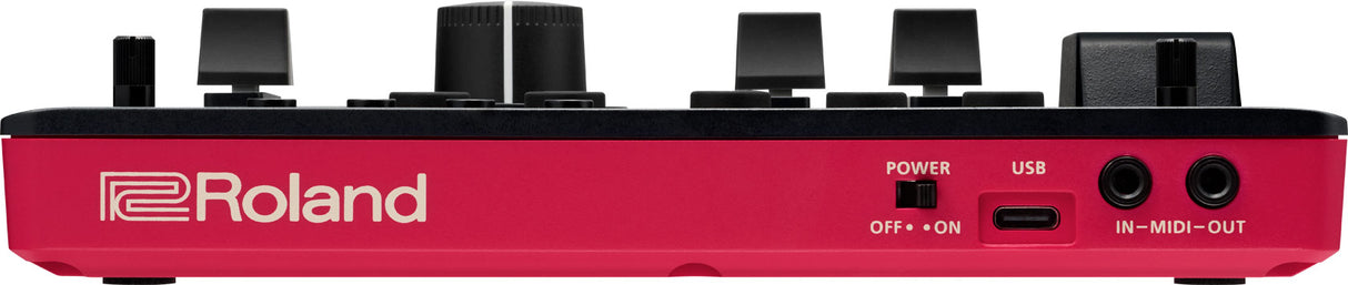 The image shows the front panel of a Roland electronic music device with a red casing and white logo. It features multiple black knobs and buttons, a POWER switch, a USB port, and MIDI IN/OUT connections. The design and controls suggest it is a synthesizer, drum machine, or music controller used for live performance and studio production.