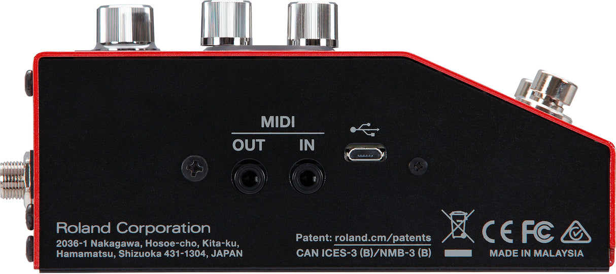The image shows the back panel of a Roland electronic music device with MIDI IN and OUT ports, a USB port, and an audio output jack. It has three metallic control knobs on top and a black casing with red trim. The device, made by Roland in Malaysia, features certification marks and a compact, rectangular design, suggesting it is a MIDI controller, audio interface, or compact synthesizer module for modern music production setups.