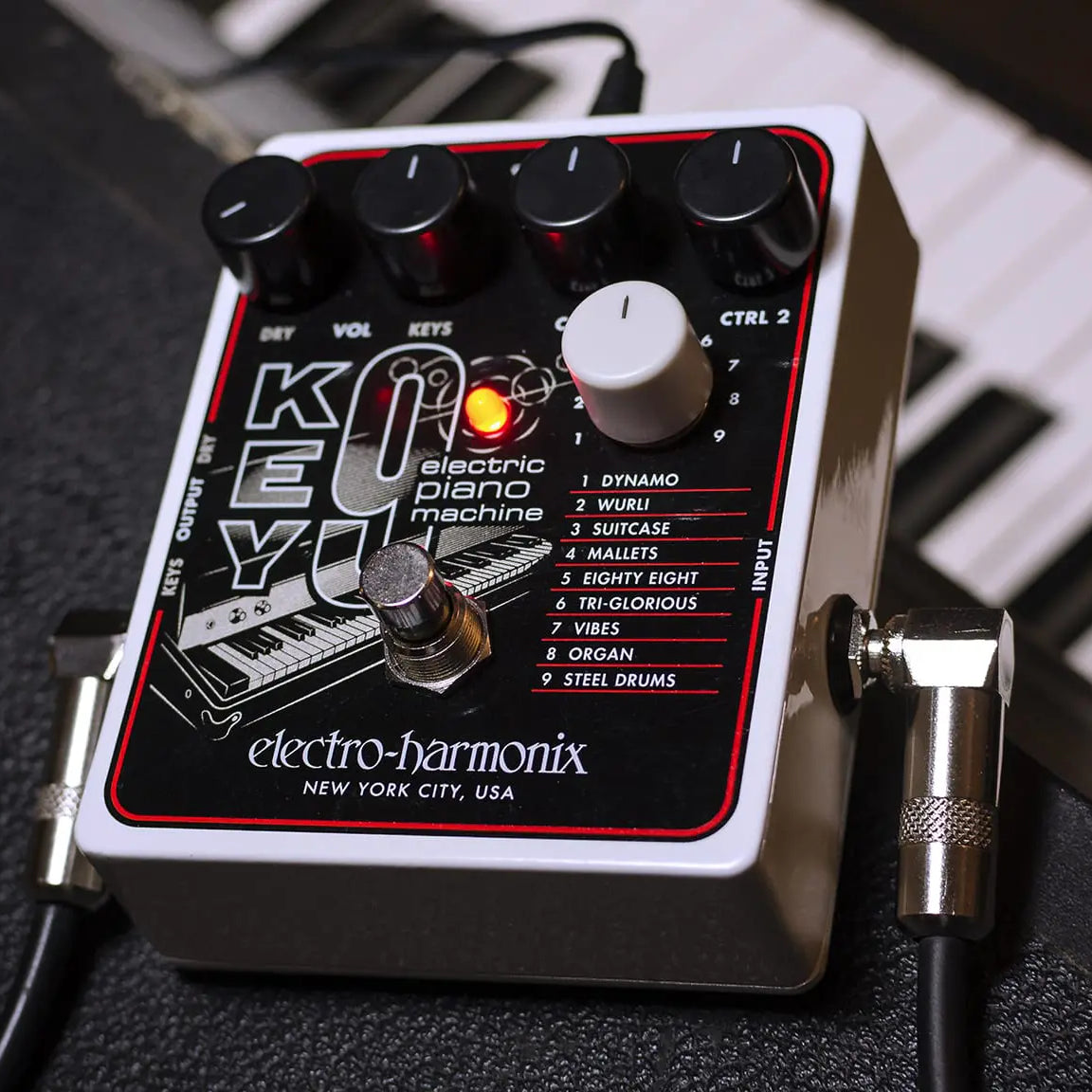 An angled view of the Electro-Harmonix Key9 synth pedal resting on a black keyboard.