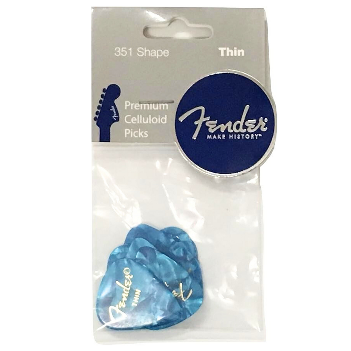 The image shows a clear package of Fender 351 Shape thin guitar picks made of blue marbled celluloid. These classic teardrop-shaped picks feature the Fender logo and "Make History" branding. Known for a warm vintage tone and flexible thin gauge, they are popular for strumming and lead playing. The packaging includes a hang tab for retail display, highlighting Fender’s quality and widely recognized design.