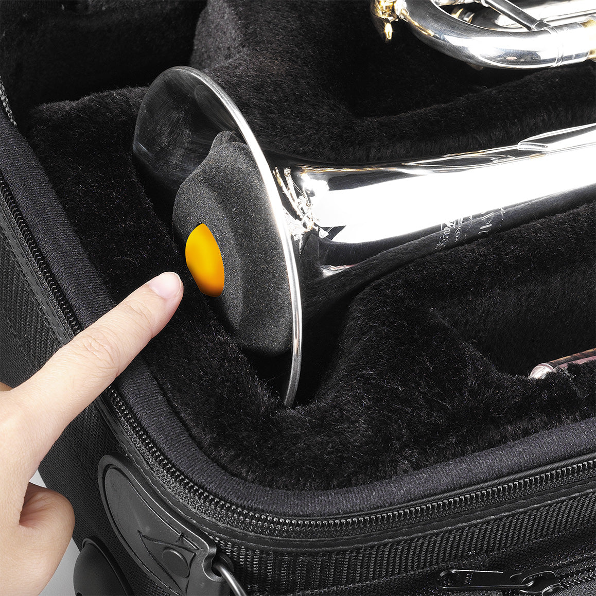 A folded up trumpet stand being stored in the bell of a trumpet inside a black case