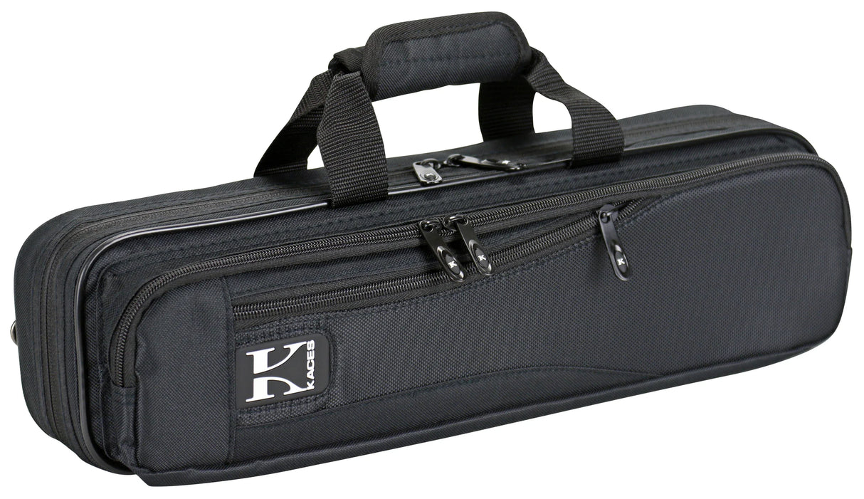 The image shows a black soft-sided flute case with a durable nylon or canvas exterior. It has dual padded carry handles, multiple zippered compartments for storage, and a brand logo patch (possibly "Kaces"). Designed for professional protection, the case is ideal for flute players to safely transport their instrument and accessories like cleaning cloths and sheet music.
