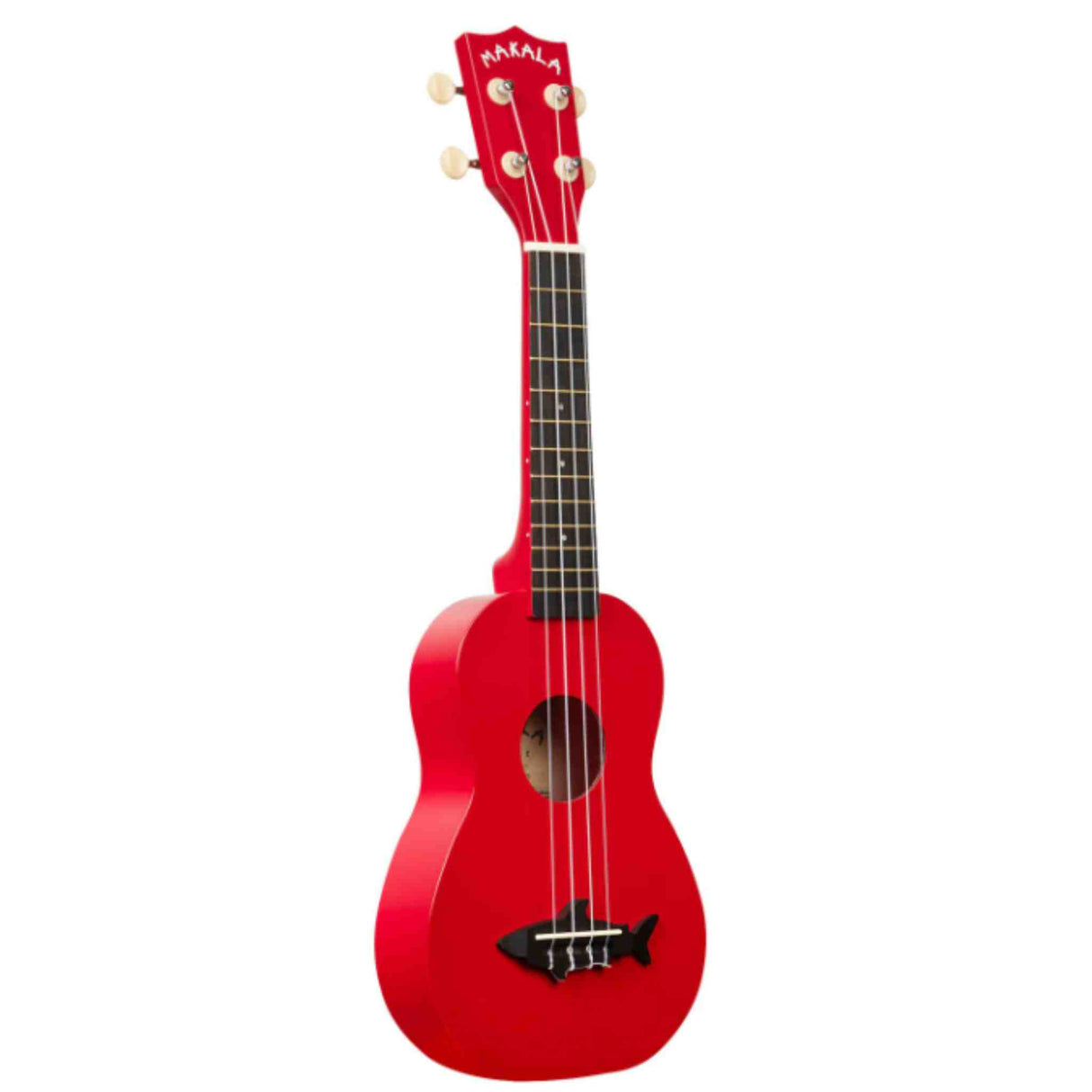 The image shows a bright red Makala ukulele with four strings and tuning pegs featuring cream-colored buttons. It has a dark fretboard, white binding around the edges, and a black fish-shaped design on the lower bout. This soprano or concert-sized instrument has a traditional body shape and is ideal for beginners seeking a vibrant, fun ukulele.