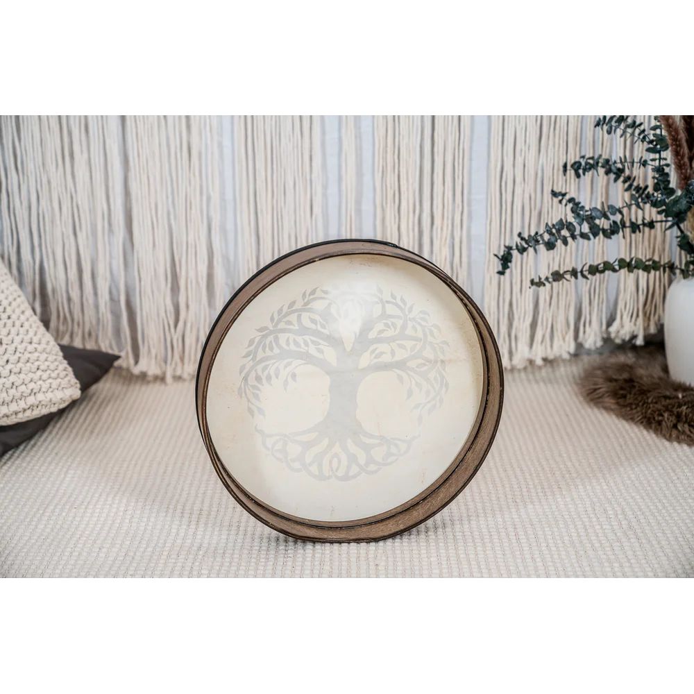 Decorative hand drum with tree of life design on a textured surface