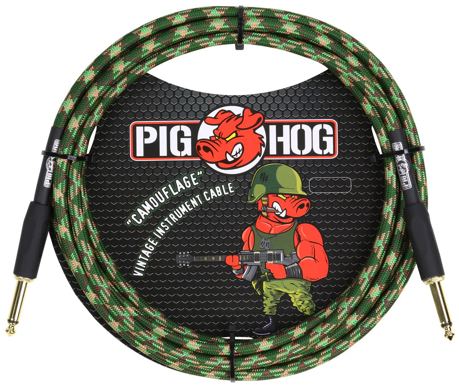 The image shows a Pig Hog brand instrument cable with a green camouflage woven jacket and gold-plated 1/4" connectors. It features the red pig mascot in military gear holding a guitar, emphasizing the military-themed vintage design. The cable is packaged in retail packaging with a black honeycomb background. This durable cable is designed for electric guitars, basses, and other instruments, offering reliable audio and a distinctive style.