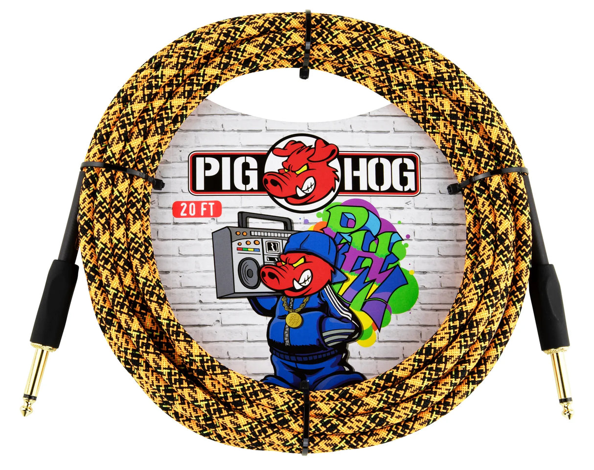 The image shows a coiled 20-foot Pig Hog instrument cable with a woven gold and black fabric exterior and gold-plated 1/4" connectors. The Pig Hog logo, featuring a pig mascot wearing headphones, is visible against a brick wall with graffiti-style art. Known for durability and low noise, this premium cable is favored by guitarists and bassists for reliable performance and extra protection.