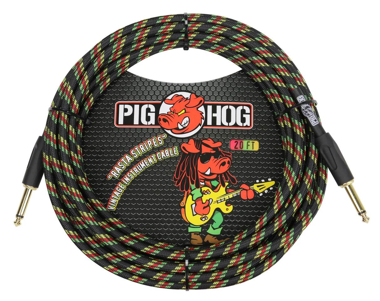 The image shows a Pig Hog 20-foot "Rasta Stripes" instrument cable with a woven fabric jacket in black, green, yellow, and red. It is coiled, featuring 1/4-inch mono jacks—one straight and one right-angle. The packaging displays the Pig Hog logo with a pig mascot playing guitar. This vintage-style cable is designed for connecting guitars, basses, and instruments to amps or audio gear.