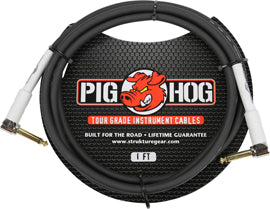 The image shows a black coiled Pig Hog instrument cable with red pig branding and silver 1/4" plugs on both ends. Designed as a touring-grade professional audio cable, it features a lifetime guarantee. The spiral design helps prevent tangling, making it ideal for electric guitars, basses, keyboards, and other electronic instruments connecting to amps or audio equipment.