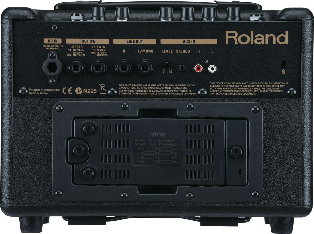 The image shows the back panel of a Roland guitar amplifier featuring DC power input, foot switch jack, left and right line outputs, and auxiliary input with level controls. It has multiple control knobs, a battery compartment with ventilation, and Roland branding. The compact, portable design supports battery operation, built-in effects, and loop control, making it suitable for practice, busking, or small performances.