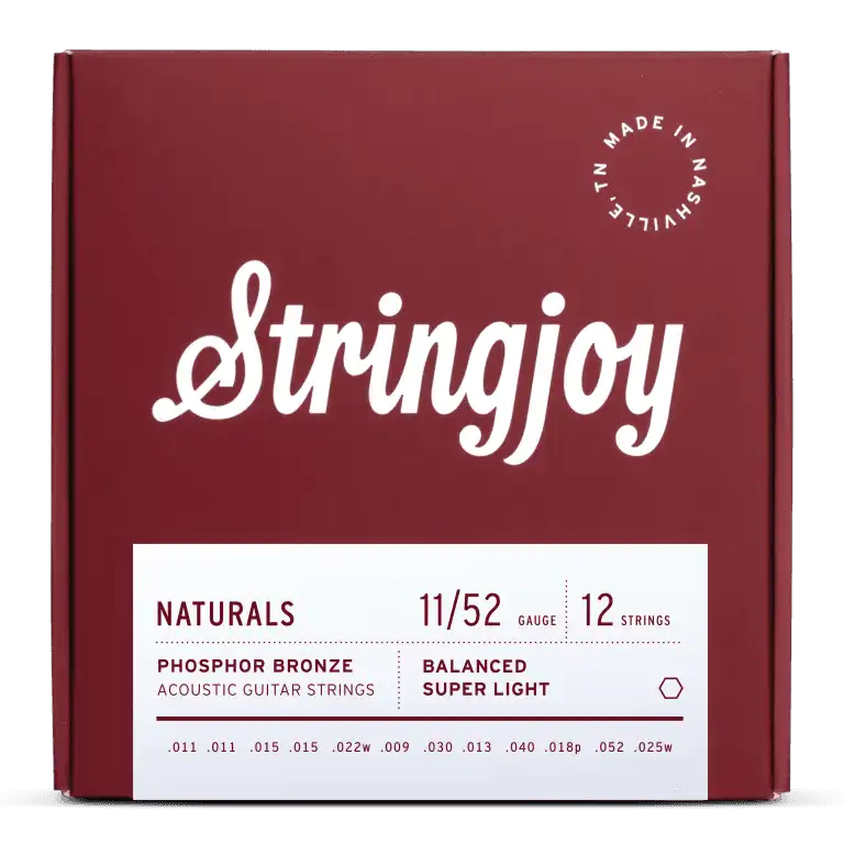 The image shows a burgundy box of Stringjoy acoustic guitar strings, a 12-string set made in Nashville, TN. These phosphor bronze strings have a balanced super light gauge of 11/52, with individual string sizes listed on the package. The design features clean white lettering and a circular "Made in Nashville TN" logo, part of the "NATURALS" product line known for warm tone and durability.