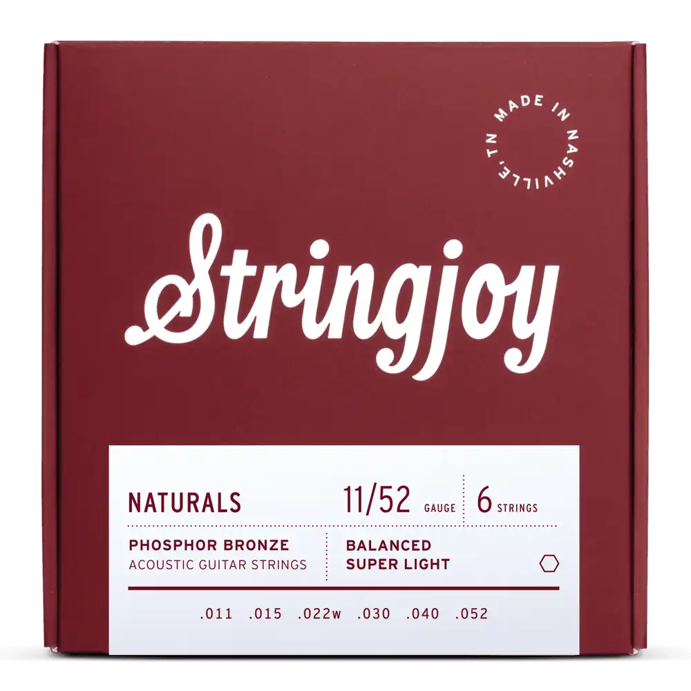 The image shows a package of Stringjoy "Naturals" phosphor bronze acoustic guitar strings in super light gauge (11-52). The deep red box features white script branding, a white info label, and a "Made in Nashville, TN" stamp. The set includes 6 strings with gauges .011, .015, .022w, .030, .040, and .052, highlighting a professional, premium presentation.