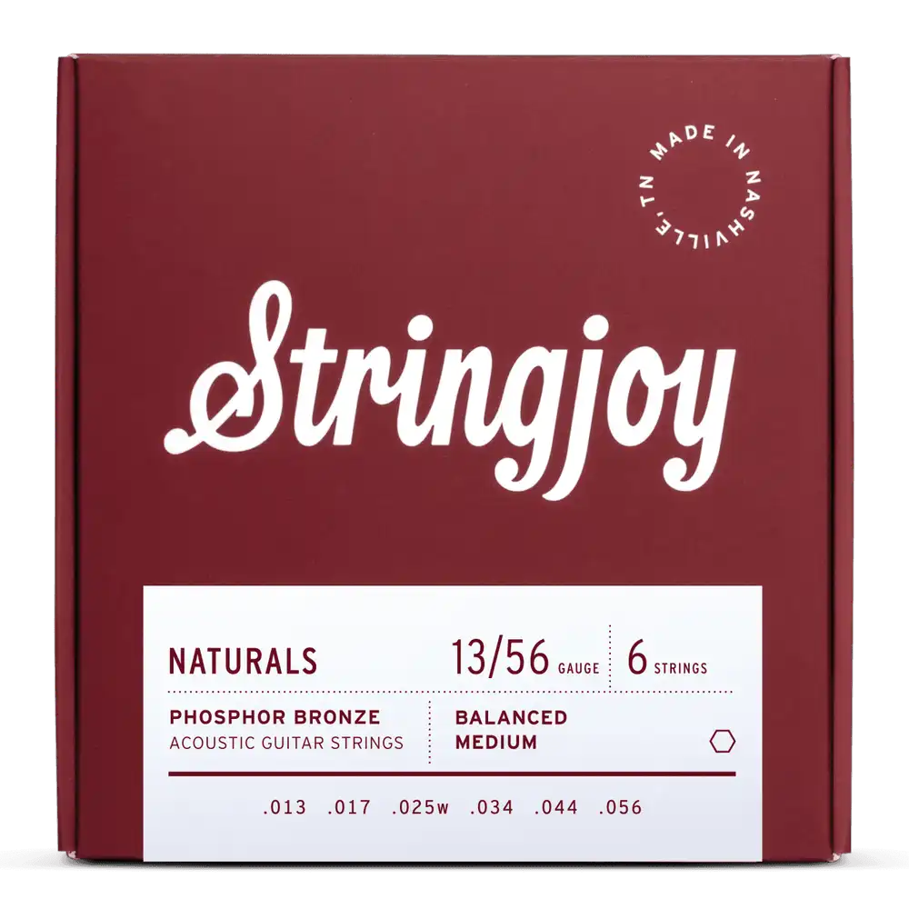The image shows a package of Stringjoy acoustic guitar strings, medium gauge (.013–.056) phosphor bronze, balanced medium tension. The deep red box features clean white script logo, "Made in Nashville, TN" in the top right, and a minimalist design. The set includes six strings, known for warm tone and durability, from Stringjoy’s "Naturals" line.