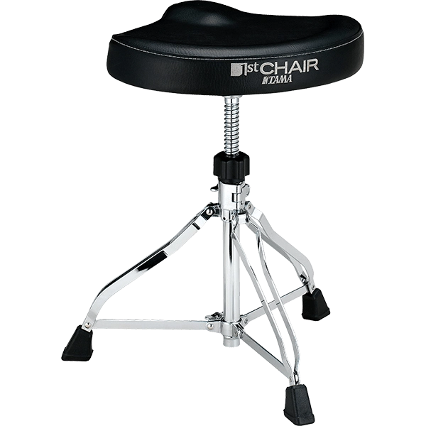 The image shows a Tama "1st CHAIR" drum throne featuring a black padded vinyl seat with ergonomic design, chrome tripod legs with rubber feet, and an adjustable height mechanism with a locking post. The sturdy, professional-grade construction and visible Tama branding highlight its role in providing drummers with stable, comfortable seating for optimal posture and performance during extended playing sessions.