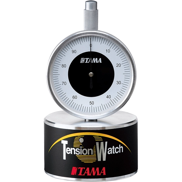 The image shows a Tama Tension Watch, a precision drum tuning tool with a 0-100 gauge dial and chrome construction. It measures drumhead tension for consistent tuning, featuring a circular base labeled "Tension Watch" and Tama branding. Ideal for drummers and technicians, it ensures even tension for studio, live, and professional use. Tama is a respected Japanese drum maker known for quality accessories.