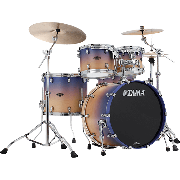 The image shows a complete TAMA drum kit featuring a bass drum with the logo, multiple tom-toms, a snare drum, and two cymbals. It has chrome hardware, including cymbal stands and adjustable supports. The drum shells display a gradient finish transitioning from light wood tones to dark blue-purple. This professional-quality set is suitable for live, studio, or practice use across various music styles.