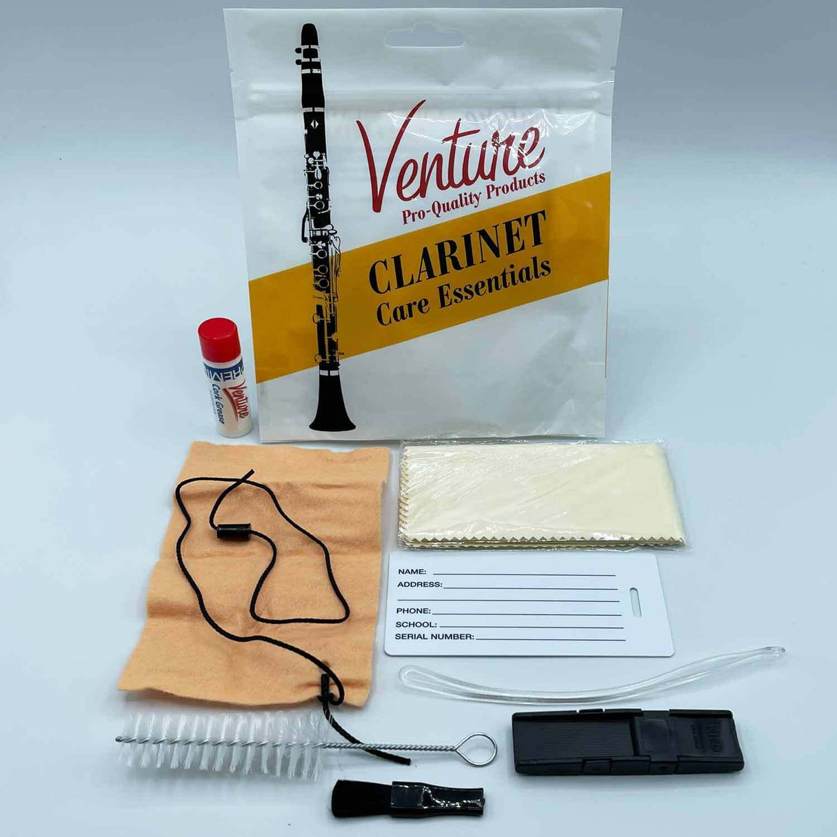 The image shows a Venture Pro-Quality clarinet care kit containing essential maintenance items: a branded clear plastic bag, a small bottle of key oil with a red cap, a tan cleaning cloth with a black pull string, a cleaning swab in packaging, a flexible cleaning rod, a small brush, a black reed case or accessory, and an identification tag for personal info. This kit helps players clean and maintain their clarinet properly.