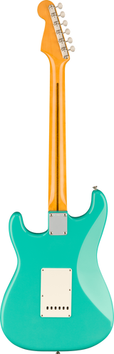 The image shows the back of a Stratocaster-style electric guitar with a glossy turquoise body and classic curves. It has an orange/amber maple neck with a maple fretboard and six tuning pegs on a Fender-style headstock. Visible hardware includes a white tremolo and pickup cavity covers, plus a metal neck plate. The vibrant color contrast and clean condition highlight this iconic American electric guitar design.