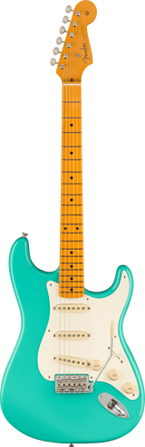 The image shows a Fender Stratocaster electric guitar with a glossy turquoise body and classic double cutaway shape. It has a maple neck and fretboard with dot inlays, a white pickguard, three single-coil pickups, chrome hardware, and tuning pegs. The headstock features the Fender logo. The combination of the vibrant finish and maple neck highlights its modern design, typical of Fender’s American or Player series.