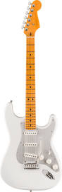 The image shows a classic Stratocaster-style electric guitar with a white/cream solid body, white pickguard, and chrome hardware. It has three white single-coil pickups, a maple neck and fretboard with an amber finish, black dot inlays, and six strings. The headstock features chrome tuning pegs, and the guitar includes a standard tremolo bridge. The warm maple neck contrasts with the white body, creating a vintage-inspired look.