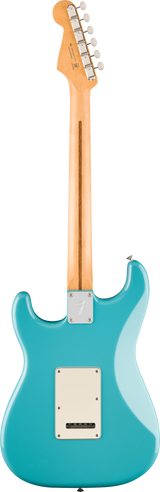 The image shows the back of a Fender Stratocaster-style electric guitar with a turquoise body and white back plate. It has a natural maple neck and headstock with six chrome tuning pegs in a row, a metal neck plate, and chrome hardware. The classic double-cutaway design and vintage finish highlight its timeless appeal, popular across many music genres since the 1950s.