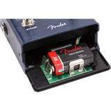The image shows a Fender guitar effects pedal with a dark blue brushed metal finish and the Fender logo. Its battery compartment is open, revealing a green circuit board, a 9V Fender Ultra Alkaline battery with red and black labels, and connecting wires. Visible are the "BYPASS" switch and a 1/4" input jack. This typical setup illustrates the pedal’s internal electronics powering guitar effects either by battery or adapter.