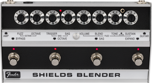 The image shows a vintage Fender Shields Blender guitar effects pedal from the late 1960s/early 1970s. It features eight labeled rotary knobs controlling fuzz, octave, trigger, sag, volume, blend, tone, and sustain. The bottom section has four footswitches with red LEDs for selecting effects modes. The Fender logo and "SHIELDS BLENDER" branding are visible. This multi-effects unit blends sounds and is now a rare collectible.