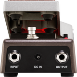 The image shows a guitar effects pedal with a sturdy metal housing and a hinged top revealing internal red-accented foot switch components. It features two 1/4" input/output jacks and a DC power input. Designed for durability, this pedal allows guitarists to modify their sound by activating effects like distortion or delay using the foot switch during performances.