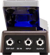 The image shows a guitar effects pedal with a metallic silver housing and a clear, blue-illuminated top revealing vacuum tubes inside. It features input/output jacks labeled "EXP OUT," "DC IN," "INPUT," and "OUTPUT." This tube-driven distortion or overdrive pedal offers warm tonal coloring, with the "EXP OUT" jack for expression pedal control. Its design suggests a high-quality, boutique-style effect device.