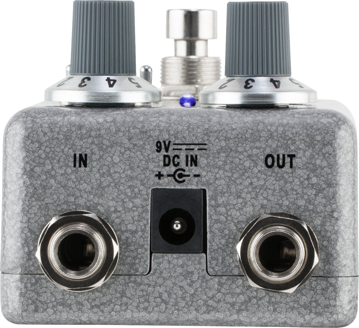 The image shows a metallic gray guitar effects pedal, likely a distortion or overdrive type. It features two control knobs, a central footswitch, and a small blue LED indicator. Input and output jacks are on the left and right, with a 9V DC power input in the center. The compact metal stompbox is designed for live use, altering guitar tone by adding distortion or overdrive in the signal chain.