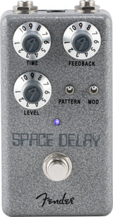 The image shows a Fender Space Delay guitar effects pedal with a compact gray/silver textured design. It has three main knobs (TIME, FEEDBACK, LEVEL), two smaller toggle switches (PATTERN, MOD), input/output jacks, a footswitch, a blue LED indicator, and the Fender logo. This digital delay pedal creates versatile echo and modulation effects, ideal for pedalboards.
