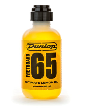 The image shows a 4 fl oz (118 ml) bottle of Dunlop Fretboard 65 Ultimate Lemon Oil, a yellow solution for cleaning and conditioning guitar fretboards. It helps remove dirt, restore natural oils, prevent drying and cracking, and keep fretboards smooth. Ideal for rosewood, ebony, and unfinished woods, this product is essential for maintaining and extending the life of guitar fretboards.