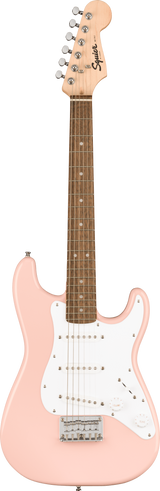 The image shows a Squier Stratocaster-style electric guitar with a distinctive shell pink finish. It features a solid body, white pickguard with three single-coil pickups, chrome hardware, a light maple headstock, and a darker fretboard with dot inlays. This budget-friendly model combines classic design and vintage-inspired style, making it ideal for beginners and intermediate players.