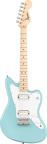 The image shows a Squier electric guitar modeled after the Fender Jazzmaster. It features a light blue/seafoam green body, white pickguard, two white-covered humbucker pickups, a maple neck with dot inlays, chrome tuning pegs, and traditional Jazzmaster offset body shape. The headstock displays the Squier logo. The hardware includes a chrome bridge and tailpiece, with standard volume, tone, and pickup controls, reflecting a vintage-inspired, affordable Fender design.