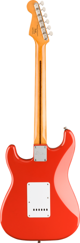 The image shows the back of a bright red/orange Stratocaster-style electric guitar with a glossy finish. It features a contoured body, white plastic back plates, and a bolt-on natural maple neck. The light-colored headstock has six chrome tuning pegs and visible branding. A metal neck plate secures the neck to the body, highlighting the clean, classic design and quality craftsmanship typical of this iconic guitar style.