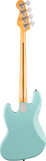 The image shows the back of a light blue or seafoam green electric bass guitar with a glossy finish. It has a natural maple neck and a bolt-on design secured by a rectangular metal neck plate. The headstock features four open-gear chrome tuning pegs with white buttons, typical of a 4-string bass. The instrument reflects a modern style inspired by classic Fender designs.