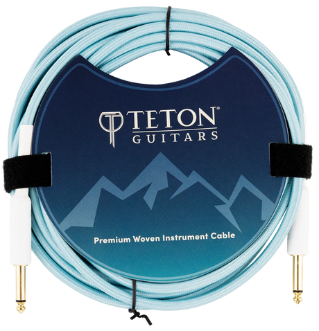 The image shows a Teton Teal 20ft guitar cable from the front, highlighting its teal-colored, coiled cable with metal connectors on both ends. The connectors have a durable, sleek design, and the cable appears flexible yet sturdy, suitable for professional guitar use. The background is plain, emphasizing the cable’s features and vibrant color.