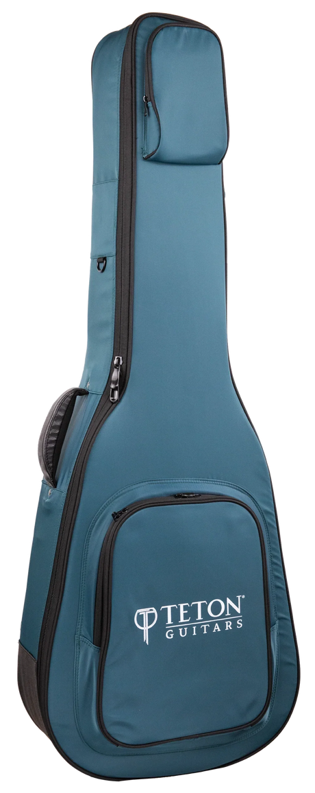 The image shows a teal/blue Teton Guitars padded gig bag shaped for acoustic guitars. It features the "TETON GUITARS" logo on the front pocket, multiple zippered compartments, padded shoulder straps, black zipper trim, and durable fabric. Designed for safe, lightweight transport, this soft case is ideal for carrying acoustic guitars and complements Teton’s branded instruments.