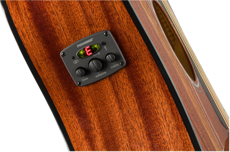 The image shows a Fishman acoustic guitar preamp and pickup system installed on a rich wood guitar body. It features a digital tuner displaying "E" in red, three control knobs for bass, volume, and treble, and a built-in chromatic tuner. The Fishman system allows players to amplify, shape tone, and tune their instrument accurately, commonly used by both amateur and professional musicians.