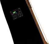 The image shows a close-up of a Fender acoustic guitar preamp/EQ system installed in a black guitar body. It features a digital tuner displaying the note "C" with Fender branding, two control knobs labeled "VOLUME" and "TONE," and a battery indicator light. Part of the guitar’s wooden edge is visible. This built-in system allows for amplification and convenient tuning during live or recording sessions.